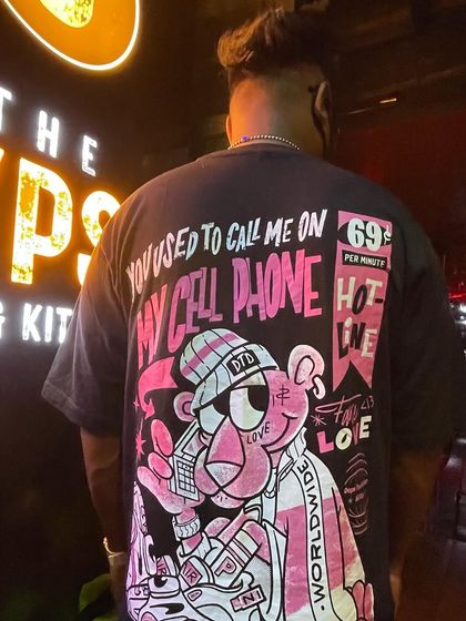 Rocking a tee that pays homage to classic hip-hop and R&B. My deep knowledge of music history allows me to create unique and memorable sets.