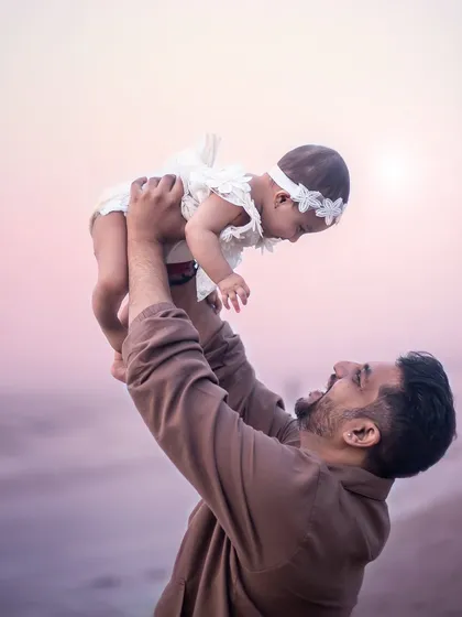 A father's love captured as he lifts his daughter up towards the sky. These are the moments that show the strength and tenderness of a father-daughter bond.