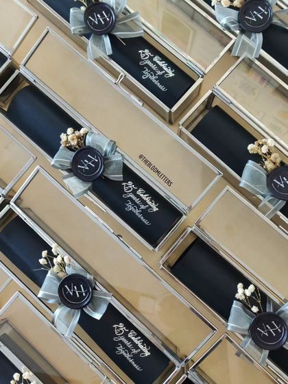 The premium invitations for a 25th wedding anniversary, neatly arranged in their glass boxes, showcasing the classic and elegant combination of black and silver.