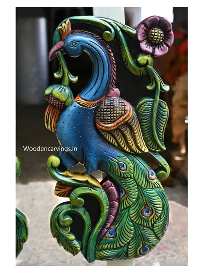 A side view of the colorful peacock, showing the graceful curve of its body and the detailed painting on its feathers.