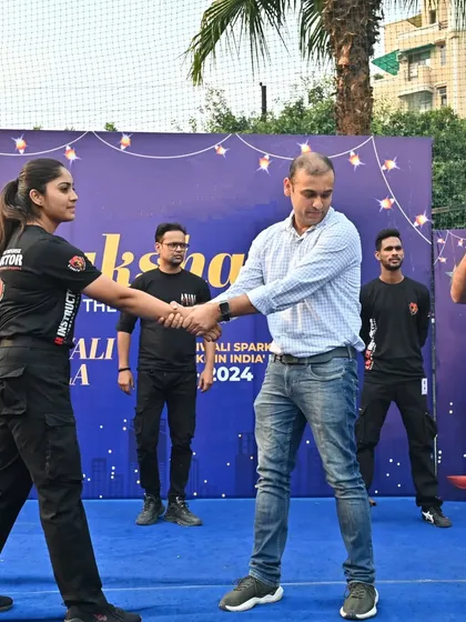 A female instructor demonstrating a wrist-grab defense to an audience member during a public event.