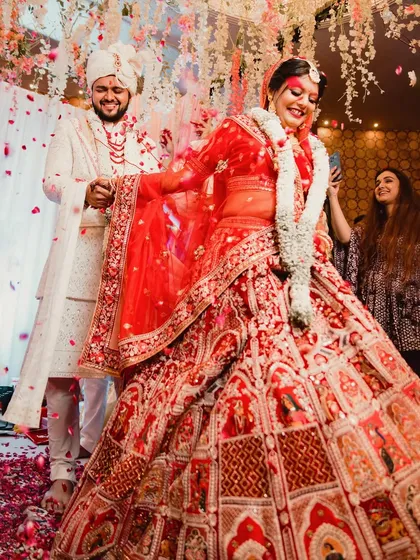 A candid shot of the bride's twirl during the wedding ceremony, with petals flying around her. This action shot captures the joy and celebratory atmosphere of the moment.