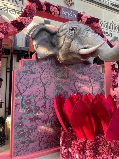 Another angle of the elephant installation, capturing the sunlight hitting the sculpture and illuminating the rich colors of the floral arch and backdrop.