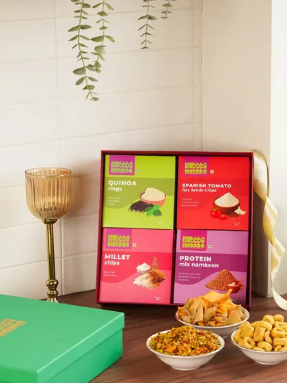 A colorful gift box of assorted healthy snacks, styled with a goblet to give it a premium, celebratory look.