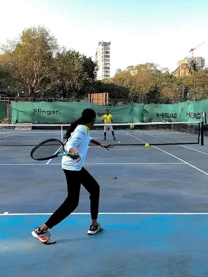 A player demonstrates a strong backhand during a rally, showcasing the skills honed at our academy.