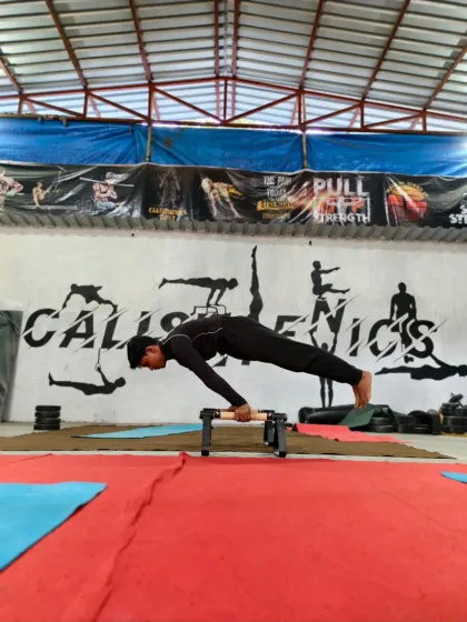 Holding a perfect pseudo planche push-up. This exercise is key for developing the straight-arm strength required for the full planche.