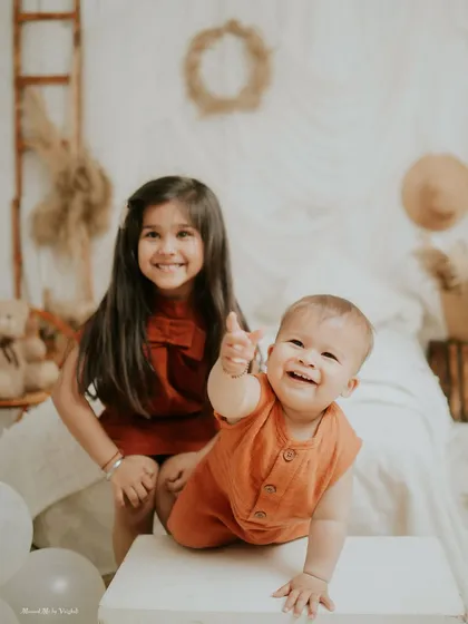 A big thumbs-up from the little brother. This playful shot is full of personality and fun.