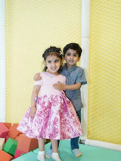A sweet moment between friends at a unicorn-themed party, posing near our soft foam block pit.
