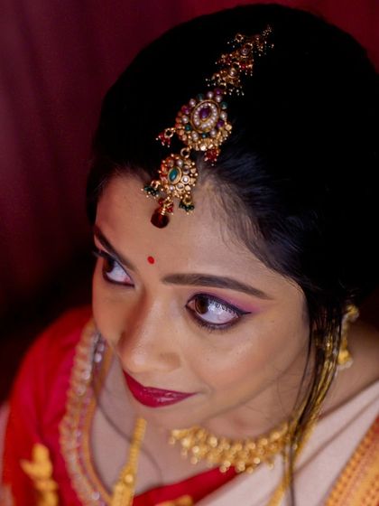 A close-up of the intricate maang tikka and the defined eye makeup, which are key elements of a traditional South Indian bridal look.