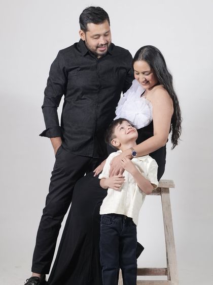 A classic family portrait. The coordinating black outfits create a timeless and cohesive look.