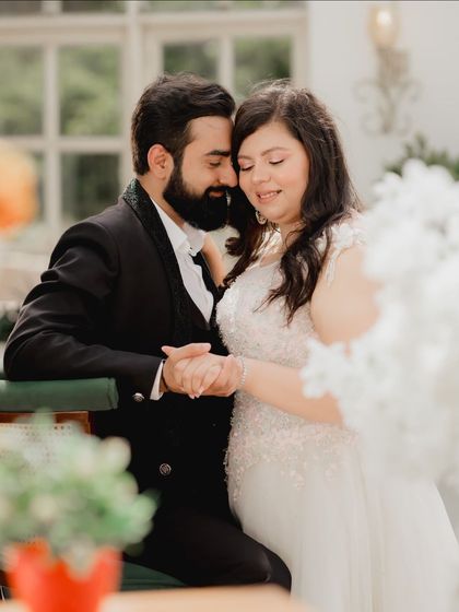 A close-up, intimate moment showing the couple holding hands. This shot focuses on their connection and the beautiful details of the bride's gown.