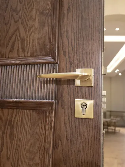 A close-up of the CNC-carved fluted door, paired with elegant brass hardware. The warmth of the metal complements the rich tones of the ash wood.