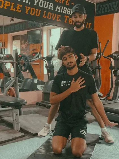 A hands-on cue during an ELDOA stretch. My role here is to provide tactile feedback, helping the athlete find the precise line of tension and position to decompress a specific spinal segment effectively.