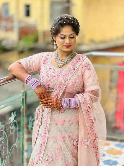 This pastel pink lehenga with floral embroidery is a dream for any bride who loves soft, romantic colours. The silver jewellery completes the look perfectly.