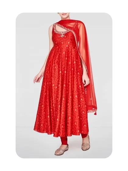 A sleeveless red Anarkali with a distinctive cutout neckline. The delicate fabric and matching sheer dupatta make it a light yet formal option for parties and celebrations. I can customize the neckline and fit to your preference.