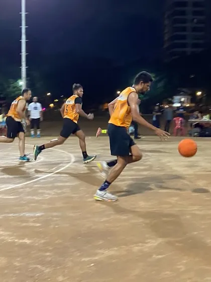 A fast break in progress. A player dribbles down the court, looking to create a scoring opportunity for his team.