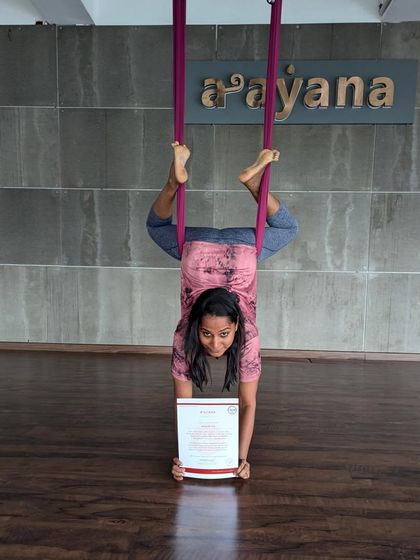 An inverted student holds her certificate with pride. This journey is about overcoming uncertainties and exploring new possibilities.