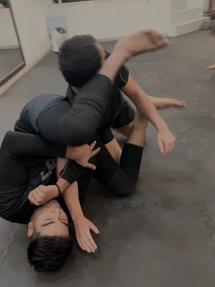 A tight armbar attempt during a live roll. We teach both how to apply and how to safely defend submissions.