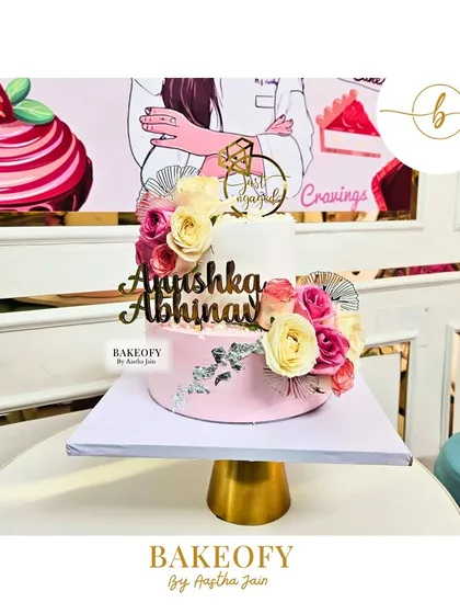 I made this 2.5 kg chocolate mousse cake for an engagement party. It features a two-tone pink and white design, decorated with elegant roses and a touch of silver for a sophisticated look.