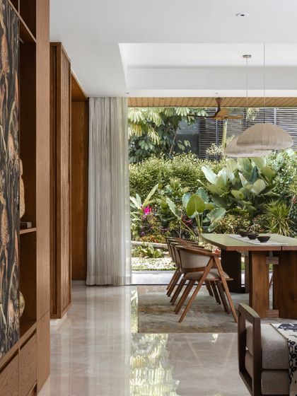 From this view, you can see how the custom shelving unit frames the dining area beyond, creating distinct zones while maintaining an open, connected feel.