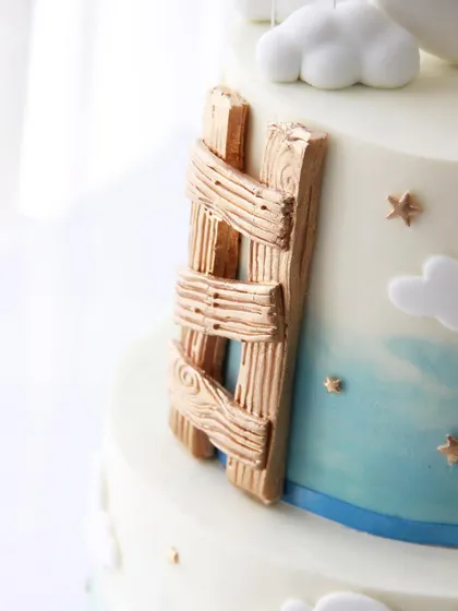 A detail shot of the fondant ladder with a realistic wood grain texture, adding a touch of rustic charm.