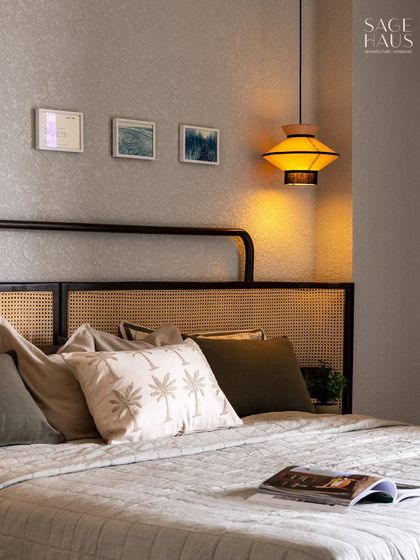 A closer look at the layered textures in this bedroom. The palm-print cushion adds a subtle tropical touch, while the open book invites you to unwind.