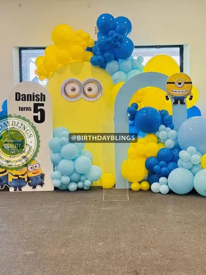 A cheerful Minions-themed party for a fifth birthday. The bright yellow and blue decor, character cutouts, and Minion-eye backdrop create a playful and mischievous atmosphere.
