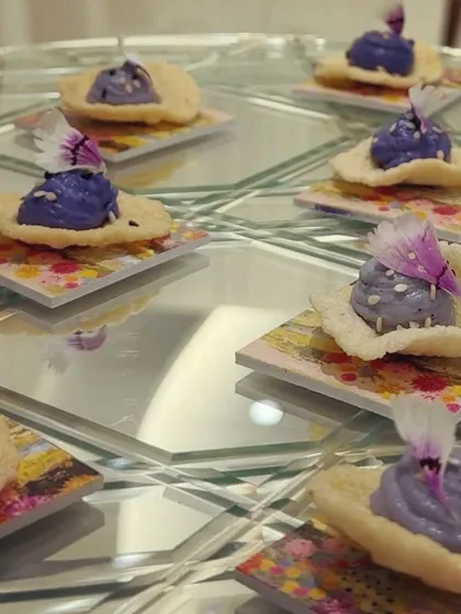 Purple sweet potato mousse on a crisp cracker, presented on colorful tiles for the Rahul Mishra launch. The color palette of the food was carefully chosen to complement the designer's collection.