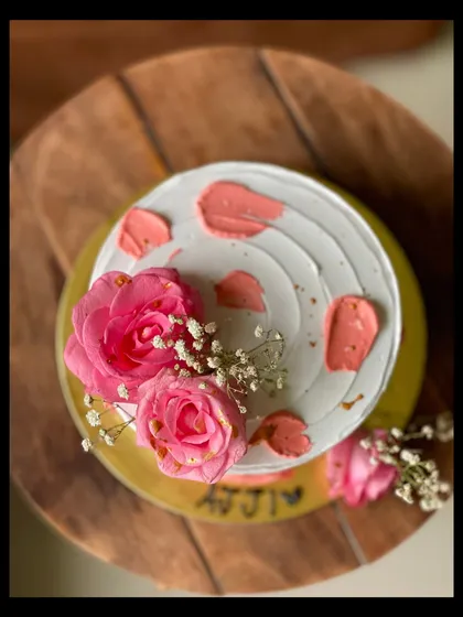 A top-down view of the cake for 'Ajji', showing the artistic placement of the fresh roses and baby's breath.