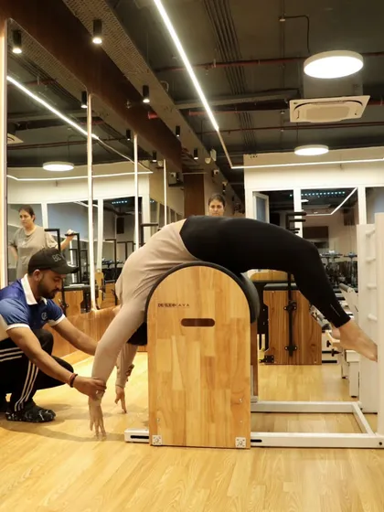 Another angle of a supported stretch on the ladder barrel, showing how we guide clients through movements that might otherwise be inaccessible, helping to increase flexibility safely.