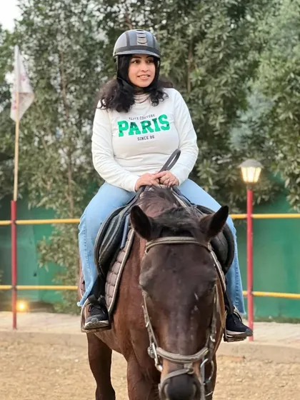 A rider smiles while mounted on one of our calm and well-behaved horses. We match riders with horses that suit their temperament and experience level.