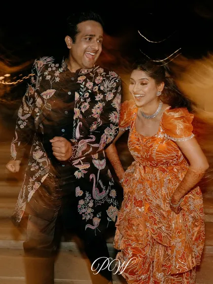 A candid shot capturing the pure joy and energy of the couple dancing at their Sangeet. The motion blur effect adds to the dynamic and lively feel of the moment.