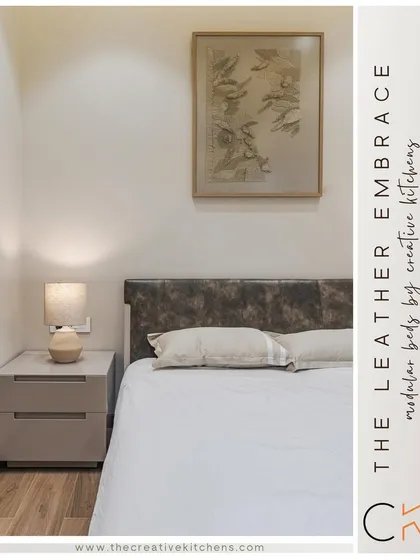 A close-up of the leather headboard and custom side table. The combination of textures, from the supple leather to the smooth finish of the furniture, adds depth and sophistication to the bedroom.
