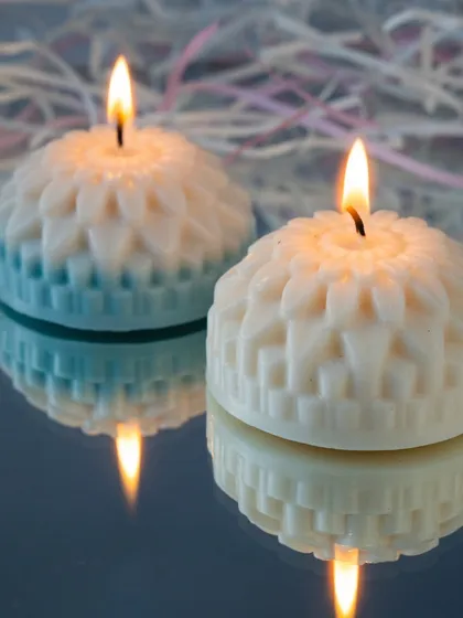 Two of our geometric flower candles lit, their reflections creating a beautiful symmetrical pattern. These are perfect for a modern aesthetic.