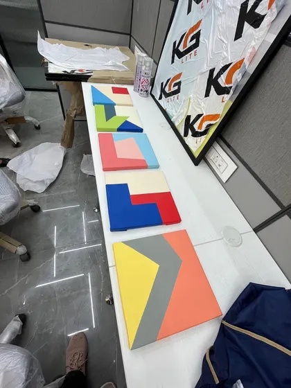 A series of smaller, colorful geometric canvas paintings laid out before installation. These can be arranged in various ways to create a custom wall feature.
