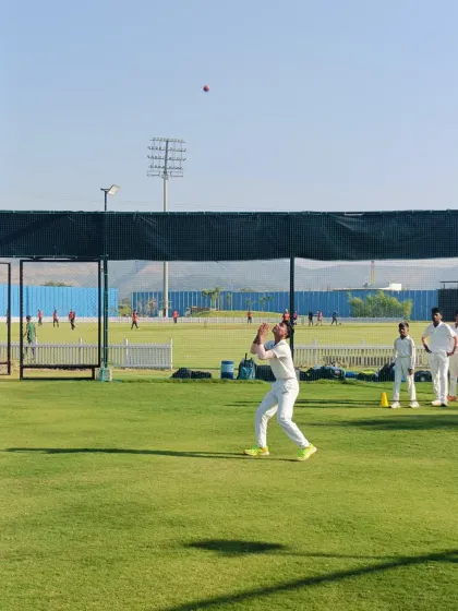 Eyes on the ball. A player positions himself perfectly to take a high catch during a fielding practice session.