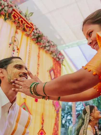 A genuine smile from the groom as a relative applies turmeric paste during the Haldi ceremony.