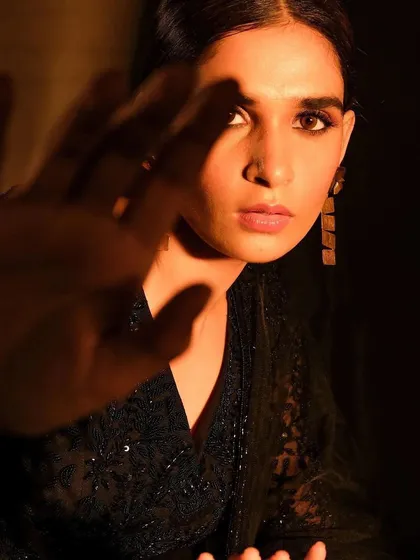 A moody and atmospheric shot for a designer campaign. The makeup is subtle yet defining, with a soft smokey eye and natural skin finish that works with the dramatic shadow play.