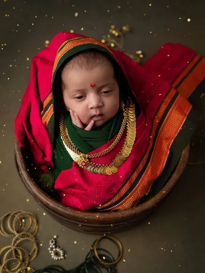 A pensive little goddess. This newborn, dressed in a traditional Maharashtrian saree wrap, looks so thoughtful and serene.