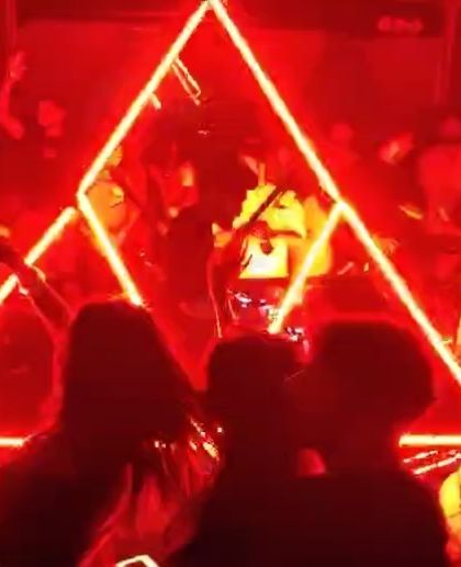 The unique pyramid lighting rig at The Fixx Bar creates an incredible visual centerpiece for the party. Here's a shot of the crowd dancing under the red glow.