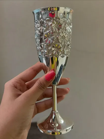 A different angle of our floral-patterned silver wine glass. The polished finish and detailed texture make every sip feel like a celebration.