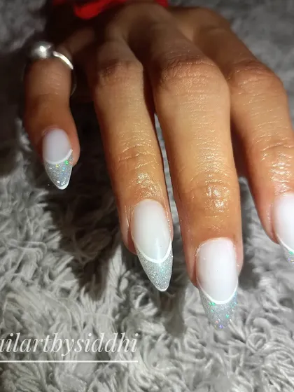 An "open French" design, where the tip is outlined in white and filled with a sparkling holographic glitter.