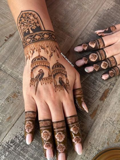 A single hand showing the bird cage motif, with delicate details on the birds and the architectural domes.