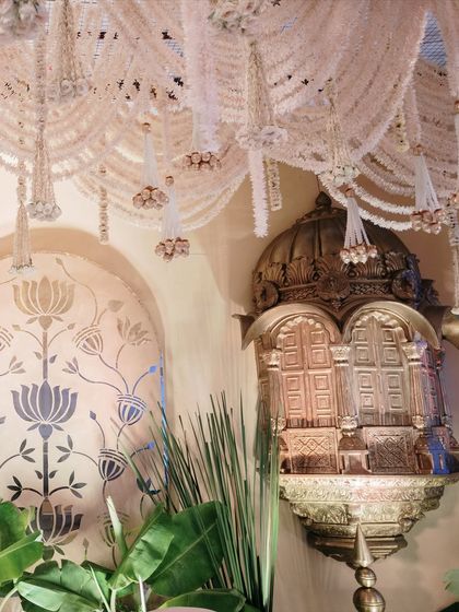 The interplay of light and shadow on the golden jharokha and the hanging floral tassels creates a dramatic and enchanting effect. This is where architecture meets artistry.