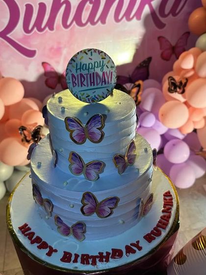 A close-up of the two-tier butterfly-themed birthday cake, which perfectly complements the party decor.