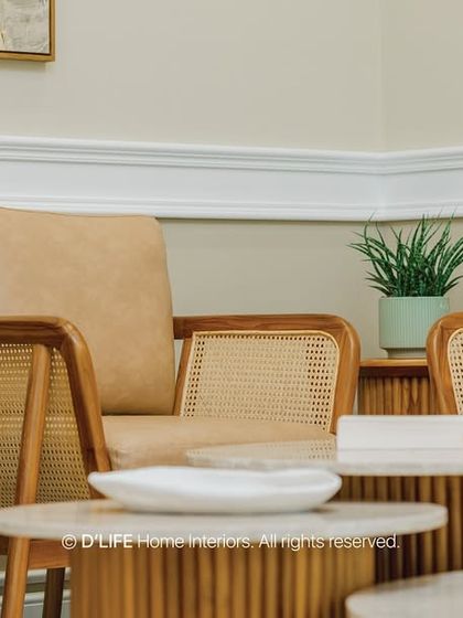 A detail shot of the living area seating, where tan leather and cane armchairs are paired with organic-shaped fluted coffee tables, showcasing a masterful mix of textures.