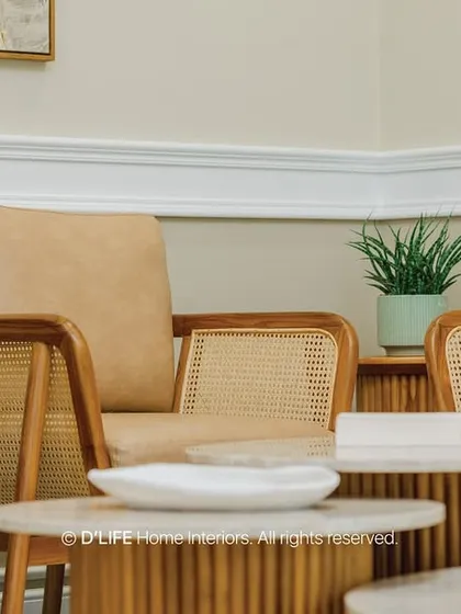 A detail shot of the living area seating, where tan leather and cane armchairs are paired with organic-shaped fluted coffee tables, showcasing a masterful mix of textures.