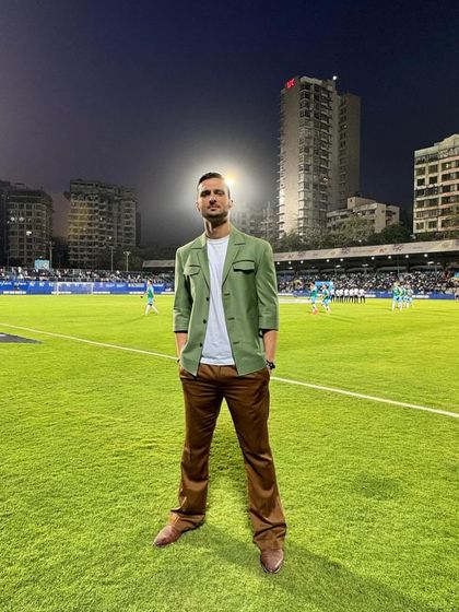 A standout look for Karan Sawhney at the Indian Super League. The combination of an olive green jacket with brown trousers is a modern take on smart-casual broadcast attire.