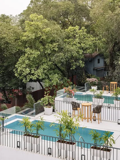 The private pools and terraces of Tellado Villas, nestled among lush trees. This view highlights our approach to creating recreational spaces that feel harmonious with nature, softening the built form.