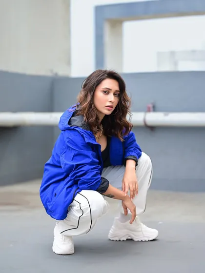 A full-body shot of Mimi's sporty look. The squatting pose is confident and strong, fitting the urban, athletic vibe of the outfit.